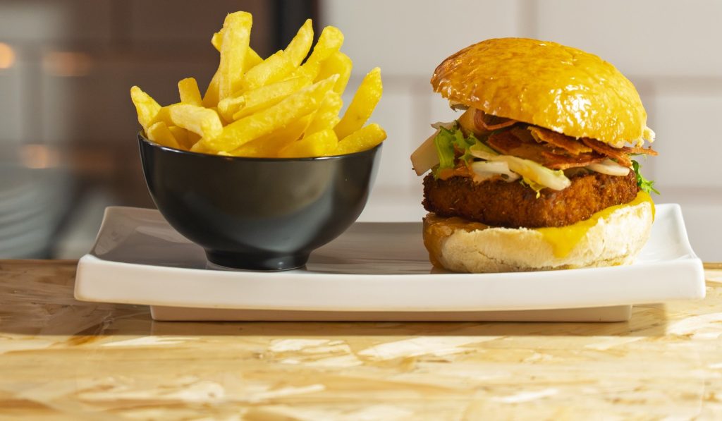 Porky Burger con pan brioche y queso cheddar junto a bowl de patatas fritas en ComePorketa — mejor restaurante de burgers cerca de la Sagrada Família Barcelona